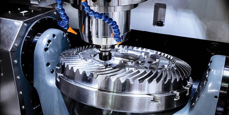 A modern CNC milling machine makes a large cogwheel.